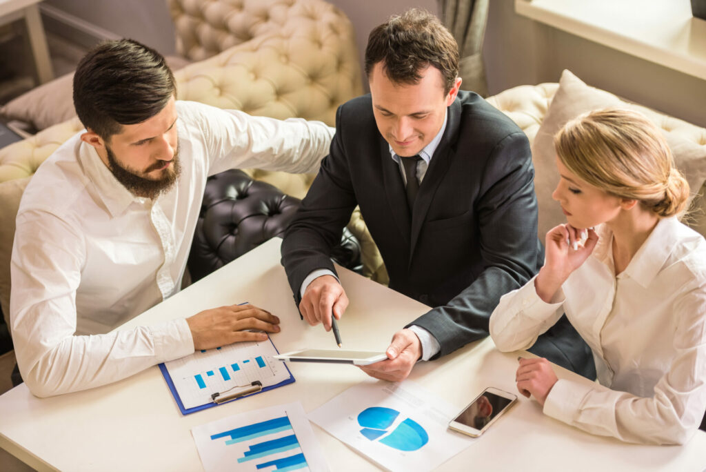 group of people at table having a business meeting looking at stats